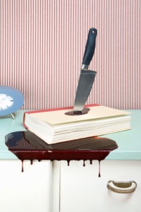 Knife stabbing a book on a dresser